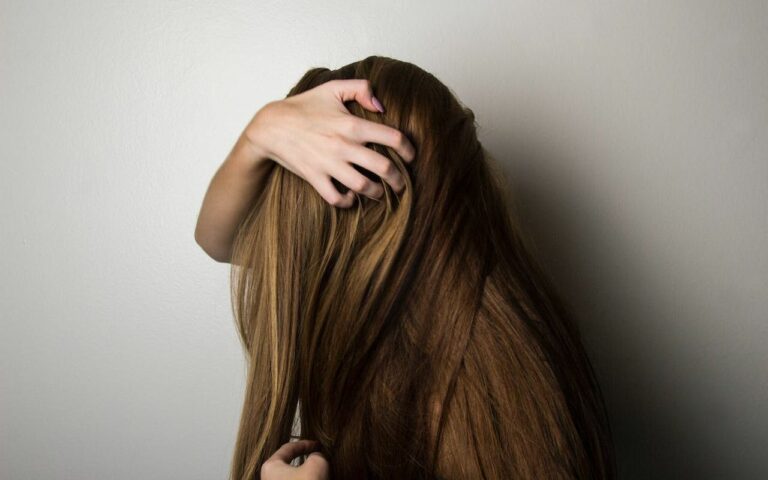 Devojka prolazi rukom kroz kosu